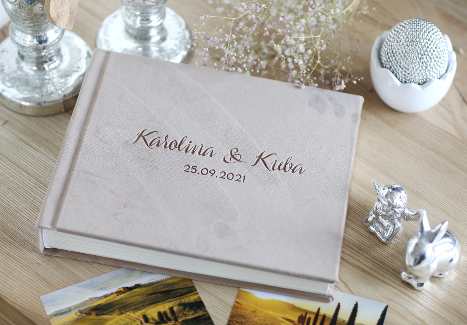 Beżowy album z wypalonym napisem Karolina & Kuba i datą